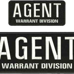May include: Two black and white embroidered patches with the text "AGENT WARRANT DIVISION" in white lettering on a black background.