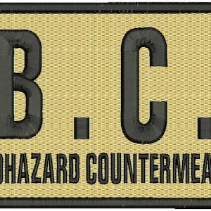 May include: A beige rectangular patch with black text that reads "U.B.C.S. UMBRELLA BIOHAZARD COUNTERMEASURE SERVICE".