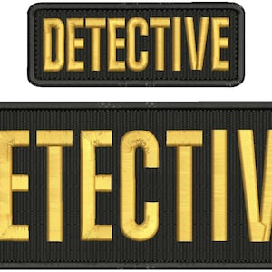 May include: Two black patches with gold embroidered text that reads "DETECTIVE".