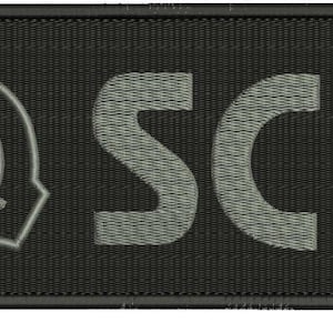 以下が含まれることがあります： グレーの刺繍されたシンボルとグレーの「SCP」という文字が書かれた黒い長方形のパッチ