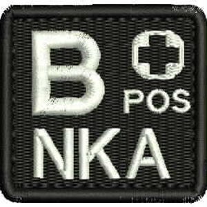 May include: Black square patch with white embroidered text and a medical symbol. The text includes "B POS" and "NKA". The patch has a black border and is likely for medical or emergency personnel.