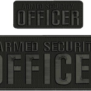 May include: Two black embroidered patches with the text "ARMED SECURITY OFFICER" in white lettering. The patches are rectangular and have a textured fabric surface.