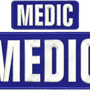 Puede incluir: Dos parches bordados blancos con la palabra "MEDIC" en mayúsculas sobre un fondo azul.