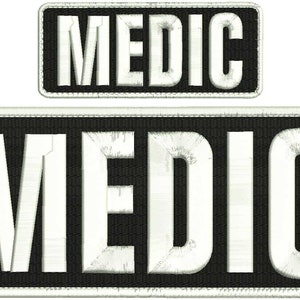 Op de afbeelding: Twee geborduurde patches in zwart en wit met het woord "MEDIC" in witte letters.
