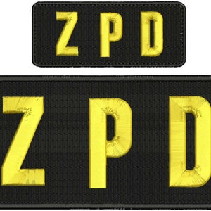May include: Two black embroidered patches with the text "ZPD" in yellow lettering. The larger patch is rectangular and the smaller patch is square.