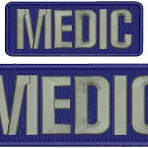 May include: Two blue rectangular patches with white embroidered text that reads "MEDIC".