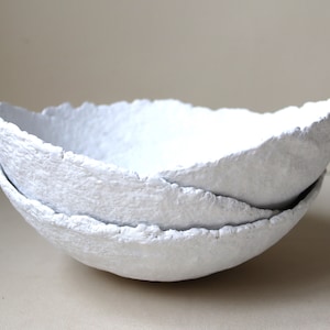 Set di tre ciotole in cartapesta bianca. Piatto decorativo in carta riciclata verniciata bianca. Decorazione d'interni fatta a mano.