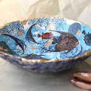 Ciotola di cartapesta blu con pesce dell'oceano e bordo dorato. Opera d'arte sostenibile in carta riciclata in stile nautico. Un regalo meraviglioso per un amico.