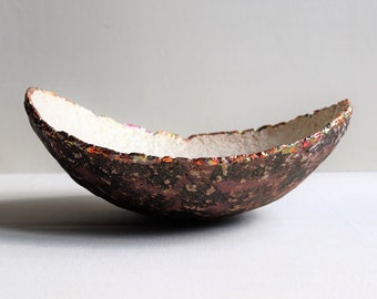Oval shaped paper mache bowl with old purple bottom and beige inside. Recycled paper pulp vessel with colored bronze rim.
