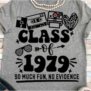 May include: Gray t-shirt with a retro design featuring a floppy disk, cassette tape, and Polaroid camera. The shirt has the words "CLASS of 1979" and "SO MUCH FUN, NO EVIDENCE" in a bold, black font. A pearl necklace is at the top.