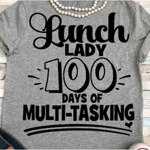 May include: Gray t-shirt with black text that reads "Lunch Lady 100 Days of Multi-Tasking".