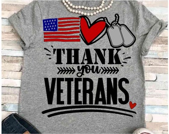 May include: Gray t-shirt with a red heart, an American flag, and two dog tags. The text "THANK you VETERANS" is printed on the shirt.