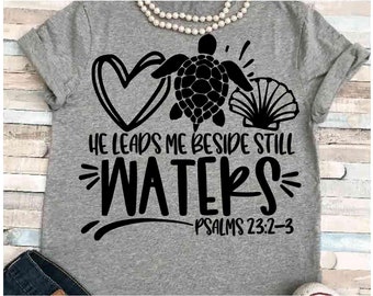 Könnte beinhalten: Graues T-Shirt mit einem schwarzen Herzen, einer Schildkröte und einer Muschel. Der Text lautet "Er führt mich an stillen Wassern" und "Psalm 23:2-3".