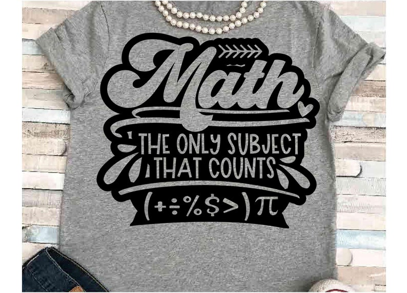 May include: A gray t-shirt with the black text "Math" above "THE ONLY SUBJECT THAT COUNTS" and math symbols. A pearl necklace is draped across the top of the shirt. The shirt is on a light blue and white wooden surface.