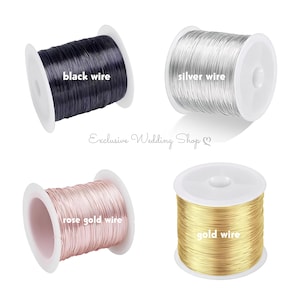 May include: Four spools of wire in black, silver, rose gold, and gold. Each spool is labeled with its respective color: "black wire", "silver wire", "rose gold wire", and "gold wire". The spools are on white plastic spools.
