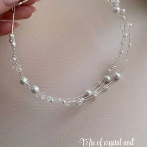 May include: A delicate silver headband with a mix of crystal and pearl beads. The headband is made of thin wire and has a circular shape.