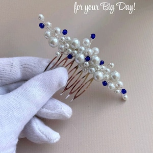 May include: A bridal hair comb featuring white faux pearls and blue accents. The comb has a silver-tone metal base and is adorned with various sizes of pearls and blue beads. Text on the image reads: "Any small color accent for your Big Day!"