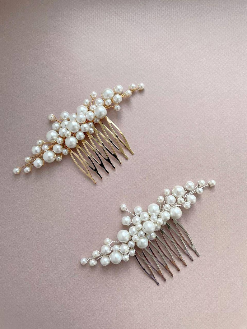 May include: Two hair combs with pearl accents. One comb has a gold finish, the other a silver finish. Both combs feature clusters of white pearls of varying sizes, arranged on a comb base for easy styling.