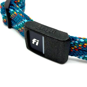 Könnte beinhalten: Nahaufnahme eines Hundehalsbands mit schwarzem Verschluss und mehrfarbigem Seildesign. Der Verschluss zeigt den Text "fi" in Weiß. Das Seil ist türkis, blau, gelb, orange und grau.