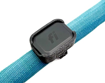 Puede incluir: Un dispositivo de seguimiento electrónico rectangular negro con las letras fi impresas en el frente, asegurado dentro de un soporte de plástico negro texturizado impreso en 3D, unido a una correa de tela tejida turquesa brillante.