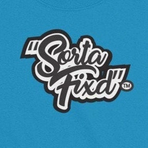 May include: A turquoise blue t-shirt with the phrase "Sorta Fixed" in a black and white design. The shirt has a crew neck and a Gildan Ultra Cotton tag.