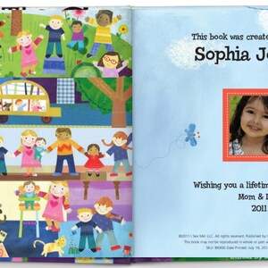 May include: A personalized children's book with a blue cover and a colorful illustration of people and vehicles. The book is titled "This book was created especially for Sophia Johnson" and includes a photo of a young girl. The text also reads "Wishing you a lifetime of happiness! Mom & Dad 2011."