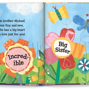 May include: A colorful book with a patchwork flower design. The text on the page reads "Little brother Michael seems tiny and new, but he has a big heart with love just for you!"  The flowers have the words "Super", "Incred-ible", "Big Sister", and "Sophia" on them.