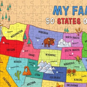 May include: A colorful map of the United States with each state outlined and labeled. The map includes state capitals and landmarks, such as the Golden Gate Bridge, Mount Rushmore, and the Grand Canyon. The title of the map is "My Family 50 States of America."