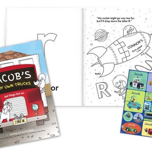 May include: A coloring and activity book for children featuring a red dump truck with the text "Jacob's Very Own Trucks" and a rocket ship with the text "Connor's Explorer". The book includes stickers with the name "Jacob" and various vehicles.