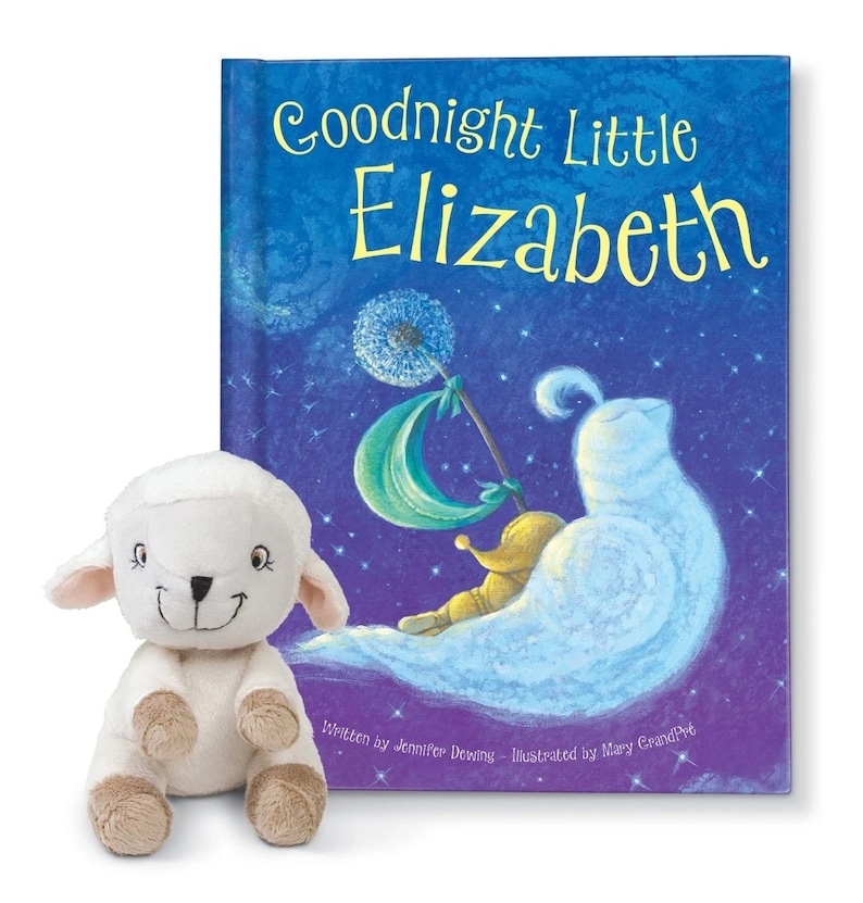 May include: A white plush lamb toy next to a blue and purple book titled "Goodnight Little Elizabeth". The book features a whimsical illustration of a sleeping child on a cloud with a dandelion.