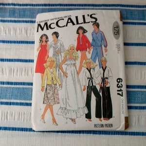 May include: McCall's sewing pattern envelope with a white background and a colorful illustration of seven women wearing different outfits. The pattern number is 6317 and the price is $1.75. The text "Carefree Patterns from McCall's" is at the top of the envelope.