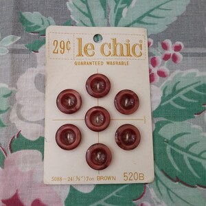 May include: A card of seven brown buttons, each with a four-hole design. The card reads "le chic" and "GUARANTEED WASHABLE". The buttons are 5/8 inch in diameter and are labeled "7on BROWN".