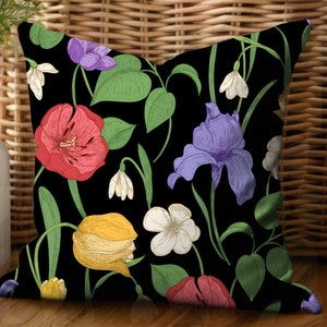 Square accent pillow with red peonies, purple irises, yellow tulips, white violets, and white snow drops on a black background