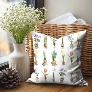 Square throw or accent pillow featuring blooming red tulip, yellow daffodil, and blue hyacinth bulbs on a white background.