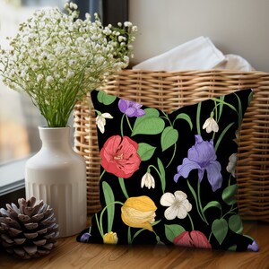 Square accent pillow with red peonies, purple irises, yellow tulips, white violets, and white snow drops on a black background