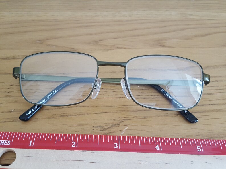 Op de afbeelding: Groene metalen bril met een montuur en heldere glazen. De pootjes van de bril zijn gemarkeerd met "SpecSAVERS 400.1228" en "54018-140 mega 25671919".