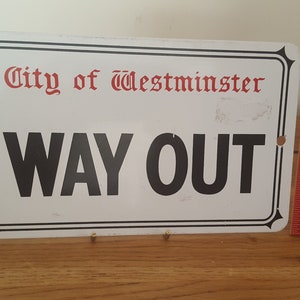Może przedstawiać: Biały metalowy znak z czarnym napisem "City of Westminster" i "WAY OUT".