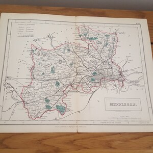 Può includere: Antica mappa del Middlesex, in Inghilterra, con cartografia dettagliata di strade, città e caratteristiche geografiche. La mappa è stampata in nero, rosso e verde su carta invecchiata, con il titolo "Middlesex".