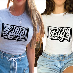 Puede incluir: Dos mujeres con camisas a juego que dicen "Little" y "Big" en una fuente negra y negrita. Las camisas son blancas y grises y tienen un borde negro alrededor de las palabras. Las palabras están rodeadas de pequeños corazones.