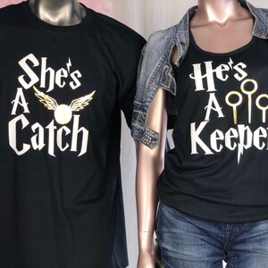 May include: Two black t-shirts with gold lettering. The shirt on the left says "She's A Catch" with a golden snitch and wings. The shirt on the right says "He's A Keeper" with three golden snitches.