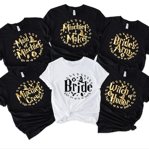 May include: Six black t-shirts with gold lettering and a witch hat graphic. The shirts say "Maid of Mischief", "Mischief Maker", "Bride's Army", "Mischief Crew", "Bride", and "Witch of Honor".