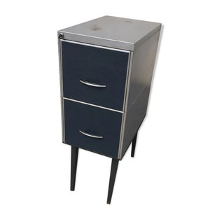 May include: A two-drawer metal filing cabinet with black drawers and silver trim. The cabinet has black metal legs.
