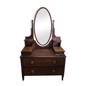 May include: A vintage wooden vanity with an oval mirror and two drawers. The vanity has a dark wood finish and ornate details.