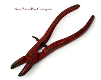 May include: Vintage red metal pliers featuring a weathered finish with visible paint wear and a central adjustment screw mechanism. The text SweetButterBlueCo.etsy.com is printed in dark purple near the top of the tool handle.