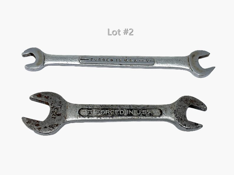 May include: Two silver-toned metal open-ended wrenches labeled Lot #2. The top wrench is smooth with the text FORGED IN U.S.A. V. The bottom wrench has a weathered, textured surface with the text 1723 and 3 FORCED IN U.S.A. stamped on it.