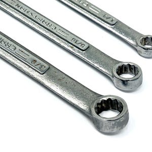 May include: Three silver-colored metal combination wrenches arranged diagonally. Each wrench features the brand name Craftsman embossed on the handle, along with size markings of 3/8 inch, 5/16 inch, and 1/4 inch respectively on the shafts.