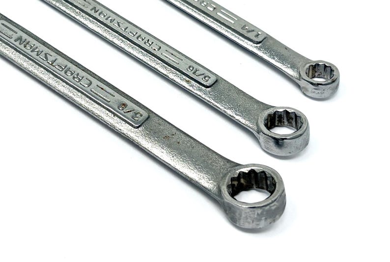 May include: Three silver-colored metal combination wrenches arranged diagonally. Each wrench features the brand name Craftsman embossed on the handle, along with size markings of 3/8 inch, 5/16 inch, and 1/4 inch respectively on the shafts.