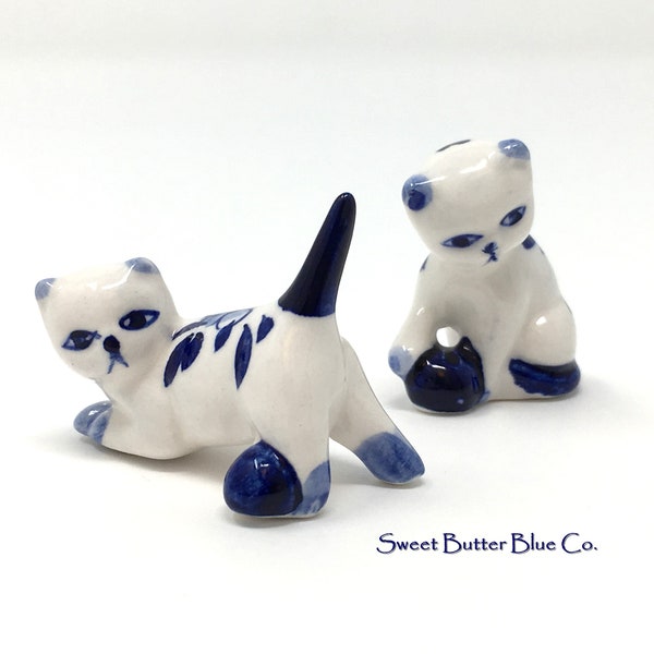 Miniature vintage kittens, cat figurines in delft style. Blue and white miniature cats playing.