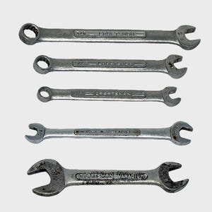 May include: A set of five silver-colored metal wrenches arranged vertically. Four wrenches feature the Craftsman brand name with sizes 3/8, 5/16, 1/4, and 5/16 inches. The bottom wrench is marked Craftsman Vanadium with 7/16 and 3/8 inch sizes.