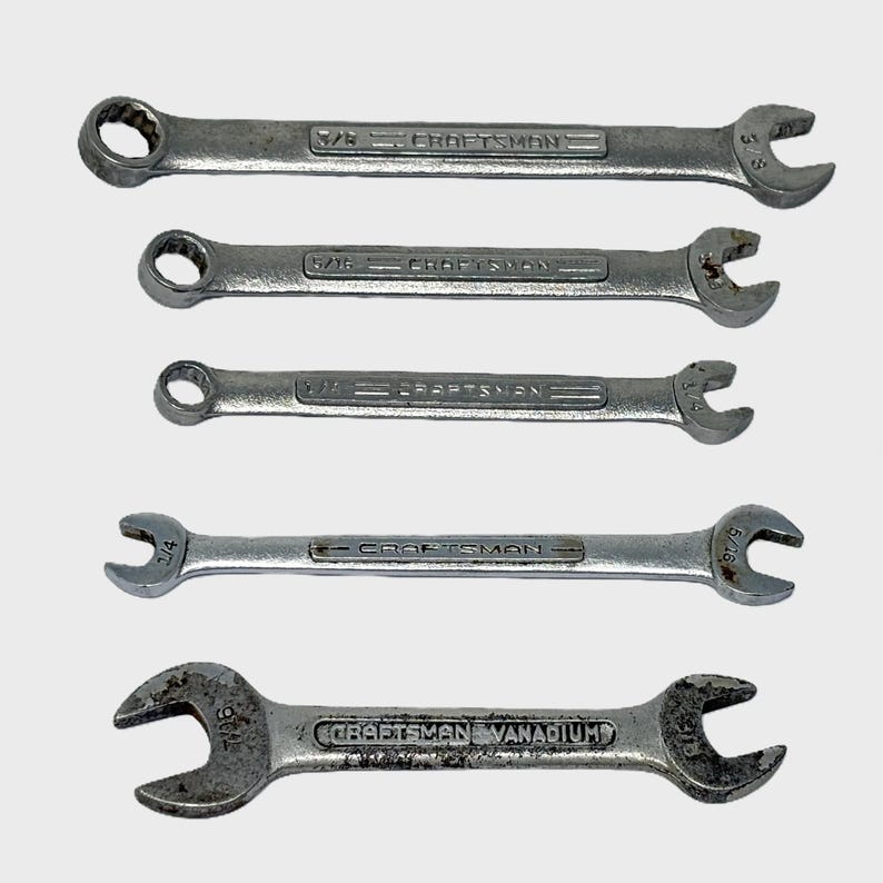 May include: A set of five silver-colored metal wrenches arranged vertically. Four wrenches feature the Craftsman brand name with sizes 3/8, 5/16, 1/4, and 5/16 inches. The bottom wrench is marked Craftsman Vanadium with 7/16 and 3/8 inch sizes.